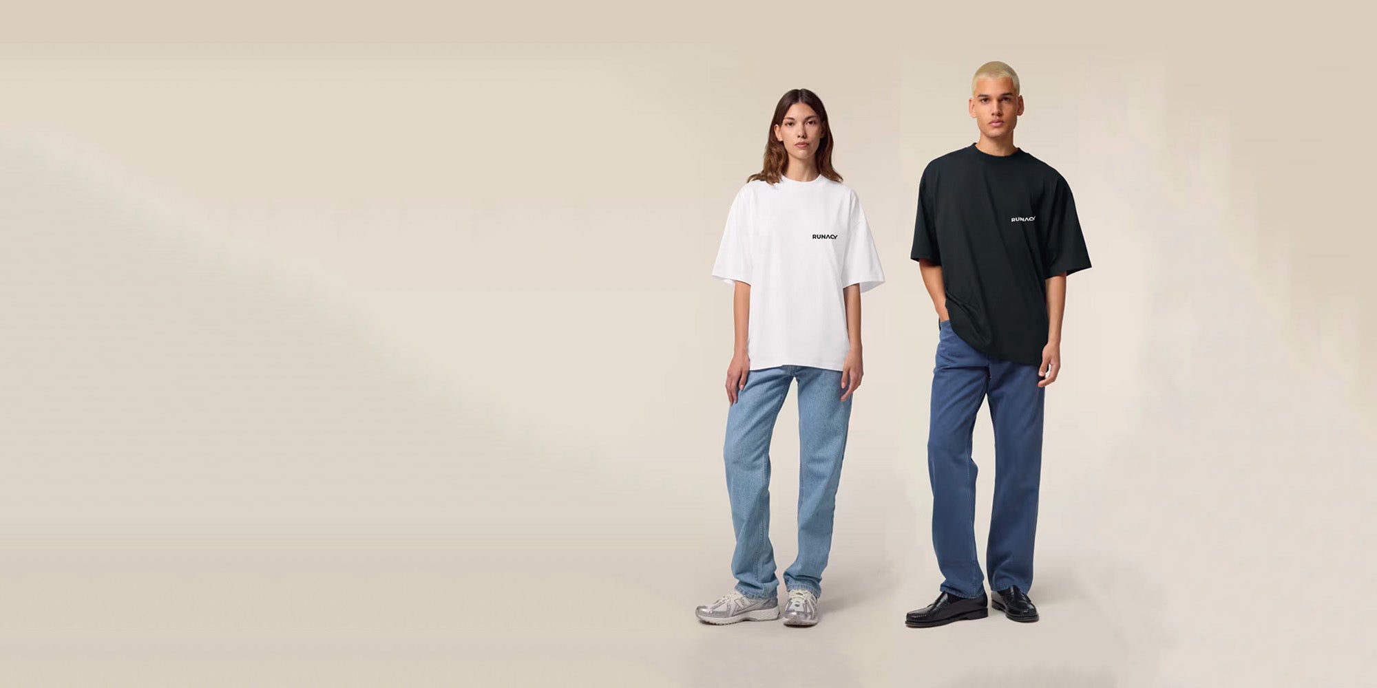 Two people wearing white and black t-shirts with blue jeans on a beige background